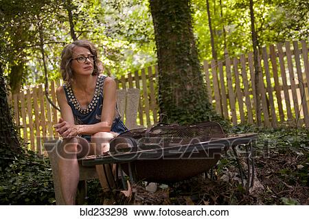 Caucasian woman sitting in backyard near fire pit View Large Photo Image Stock Photo - Caucasian woman sitting in backyard near fire pit. Fotosearch