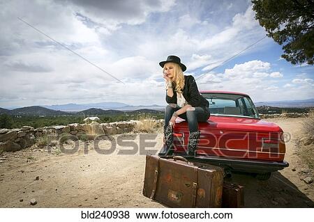 Caucasian woman sitting on trunk of car with suitcases View Large Photo Image Stock Photo - Caucasian woman sitting on trunk of car with suitcases. Fotosearch