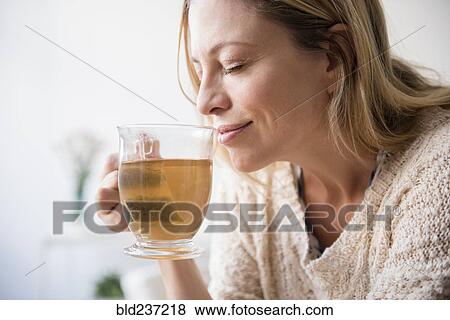 Caucasian woman smelling cup of tea View Large Photo Image Stock Photo - Caucasian woman smelling cup of tea. Fotosearch