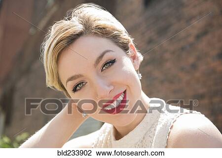 Caucasian woman smiling near brick wall View Large Photo Image Stock Image - Caucasian woman smiling near brick wall. Fotosearch