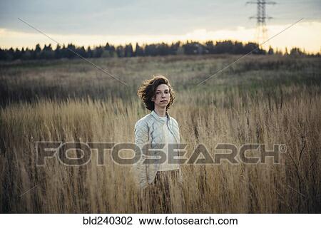 Caucasian woman standing in field of tall grass View Large Photo Image Stock Image - Caucasian woman standing in field of tall grass. Fotosearch