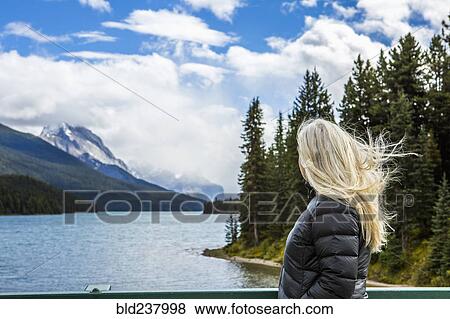 Caucasian woman standing near mountain lake View Large Photo Image Stock Photo - Caucasian woman standing near mountain lake. Fotosearch