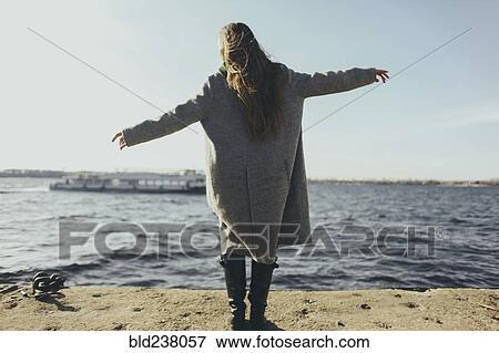 Stock Photo - Caucasian woman standing near ocean. Fotosearch