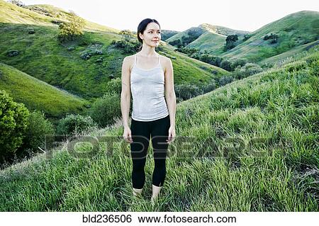 Stock Photograph - Caucasian woman standing on hill looking away. Fotosearch