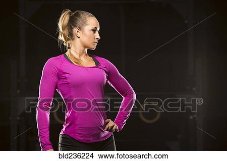 Caucasian woman standing with hand on hip in gymnasium View Large Photo Image Picture - Caucasian woman standing with hand on hip in gymnasium. Fotosearch