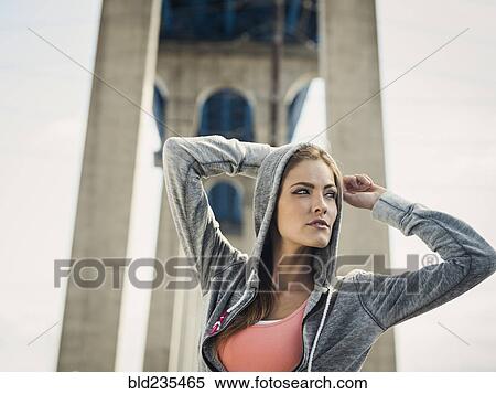 Caucasian woman stretching arms under overpass View Large Photo Image Stock Photography - Caucasian woman stretching arms under overpass. Fotosearch