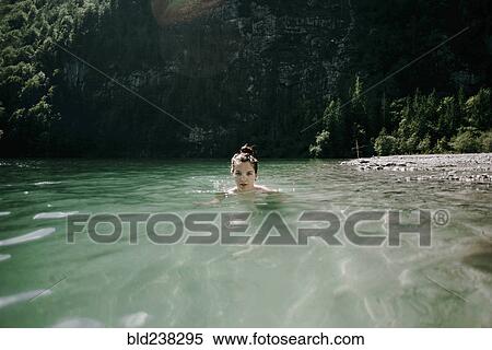 Stock Photography - Caucasian woman swimming in mountain lake. Fotosearch