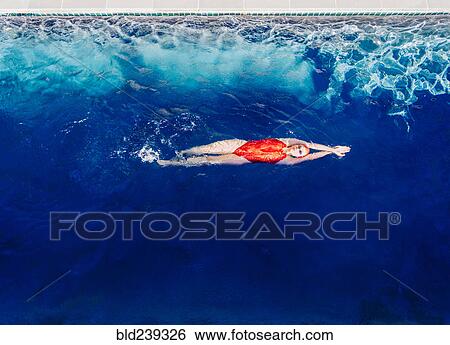 Stock Photograph - Caucasian woman swimming in swimming pool. Fotosearch