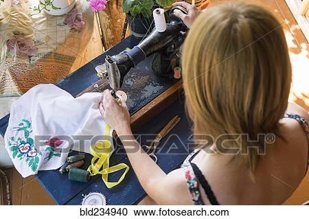 Stock Image - Caucasian woman using sewing machine. Fotosearch