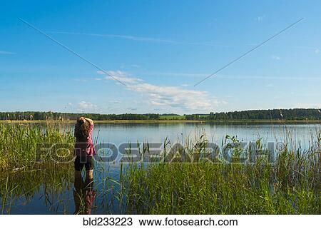 Stock Image - Caucasian woman wading in river. Fotosearch