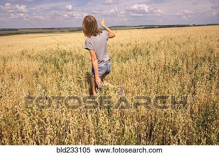Stock Photography - Caucasian woman walking in field. Fotosearch
