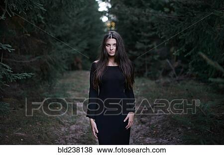 Caucasian woman wearing black dress in forest View Large Photo Image Stock Photo - Caucasian woman wearing black dress in forest. Fotosearch
