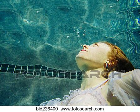 Caucasian woman wearing dress swimming underwater View Large Photo Image Stock Image - Caucasian woman wearing dress swimming underwater. Fotosearch
