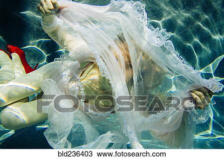 Caucasian woman wearing dress swimming underwater View Large Photo Image Stock Image - Caucasian woman wearing dress swimming underwater. Fotosearch