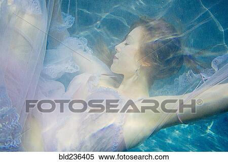 Caucasian woman wearing dress swimming underwater View Large Photo Image Stock Photography - Caucasian woman wearing dress swimming underwater. Fotosearch