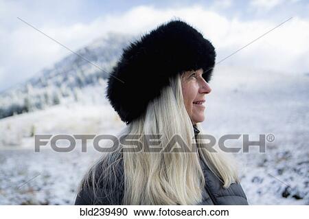 Stock Image - Caucasian woman wearing fur hat in winter. Fotosearch