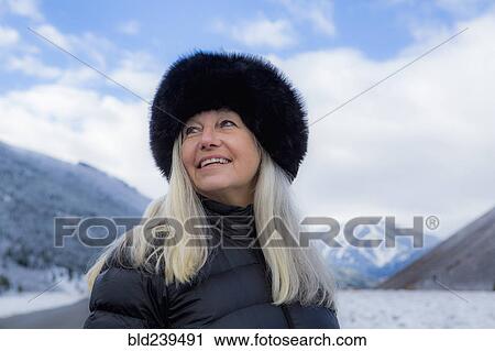 Stock Image - Caucasian woman wearing fur hat in winter. Fotosearch