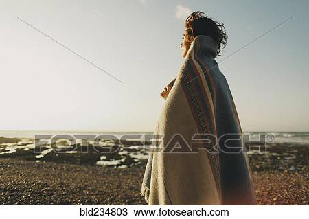 Caucasian woman wrapped in blanket at beach View Large Photo Image Stock Image - Caucasian woman wrapped in blanket at beach. Fotosearch