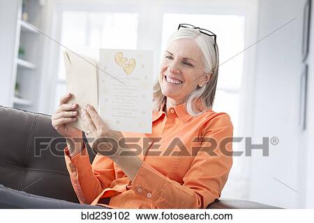 Stock Image - Caucasian women reading greeting card. Fotosearch