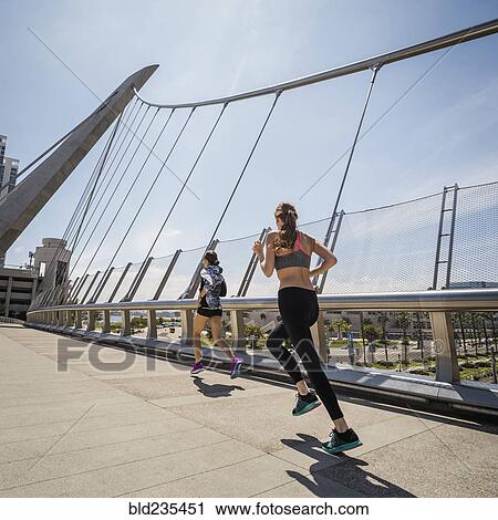 Caucasian women running on bridge View Large Photo Image Stock Image - Caucasian women running on bridge. Fotosearch
