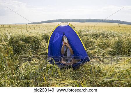 Caucasian women sitting in tent taking cell phone selfie View Large Photo Image Stock Photo - Caucasian women sitting in tent taking cell phone selfie. Fotosearch