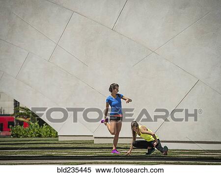 Caucasian women stretching legs near architecture View Large Photo Image Stock Photography - Caucasian women stretching legs near architecture. Fotosearch