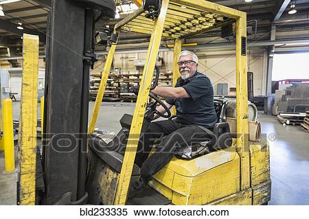 Caucasian worker driving forklift in factory View Large Photo Image Stock Photography - Caucasian worker driving forklift in factory. Fotosearch