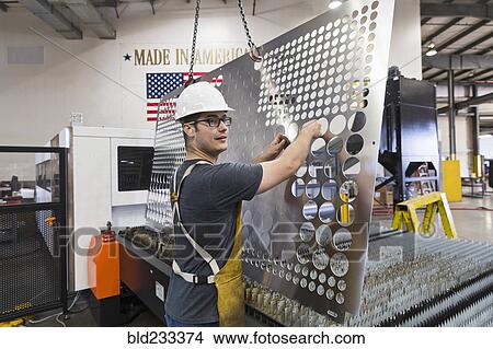 Caucasian worker fabricating metal in factory View Large Photo Image Picture - Caucasian worker fabricating metal in factory. Fotosearch