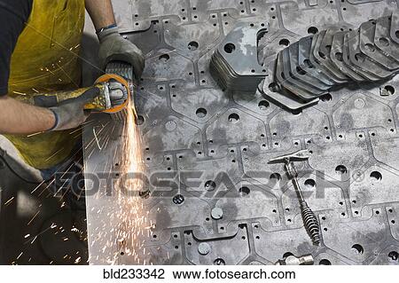 Caucasian worker grinding metal in factory View Large Photo Image Stock Image - Caucasian worker grinding metal in factory. Fotosearch