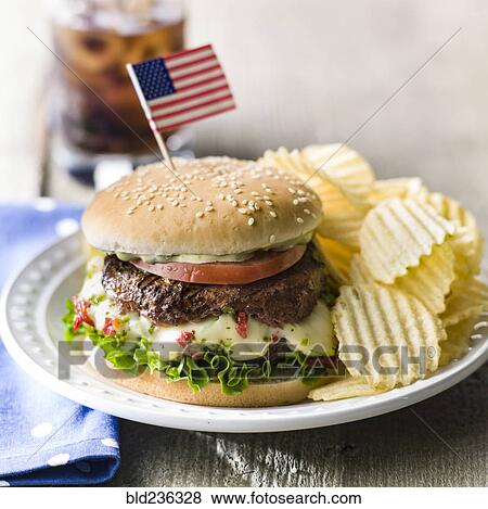 Cheeseburger and potato chips with American flag View Large Photo Image Stock Photo - Cheeseburger and potato chips with American flag. Fotosearch