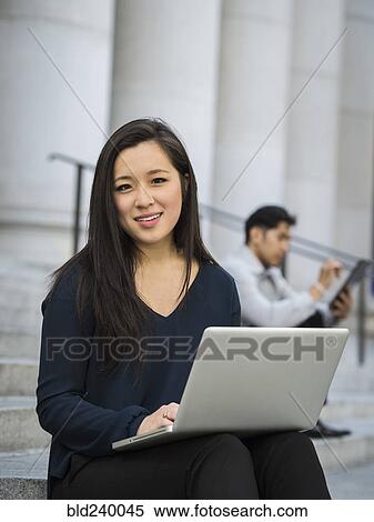 Chinese businesswoman sitting on staircase using laptop View Large Photo Image Stock Photography - Chinese businesswoman sitting on staircase using laptop. Fotosearch