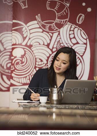 Chinese businesswoman writing in notebook in restaurant View Large Photo Image Stock Image - Chinese businesswoman writing in notebook in restaurant. Fotosearch