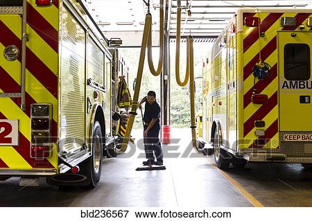 Chinese fireman sweeping floor near fire trucks View Large Photo Image Stock Photo - Chinese fireman sweeping floor near fire trucks. Fotosearch