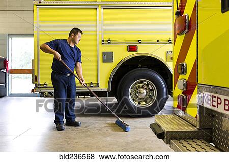 Chinese fireman sweeping floor near fire trucks View Large Photo Image Stock Photo - Chinese fireman sweeping floor near fire trucks. Fotosearch