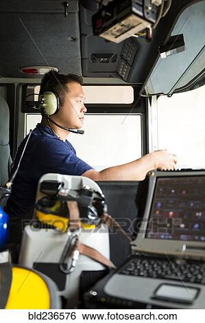 Chinese fireman wearing headphones driving fire truck View Large Photo Image Stock Photograph - Chinese fireman wearing headphones driving fire truck. Fotosearch