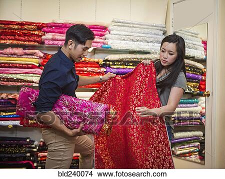 Chinese man and woman shopping for fabric View Large Photo Image Picture - Chinese man and woman shopping for fabric. Fotosearch