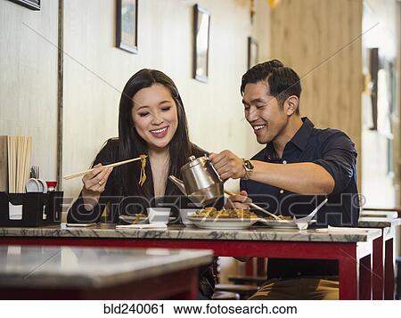 Chinese man pouring tea for woman in restaurant View Large Photo Image Stock Image - Chinese man pouring tea for woman in restaurant. Fotosearch