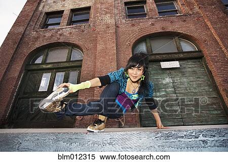 Stock Photography - Chinese woman breakdancing in urban area. Fotosearch
