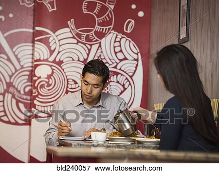 Stock Photo - Chinese woman pouring tea in restaurant. Fotosearch