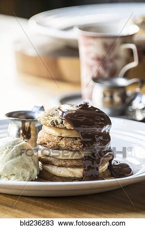 Stock Image - Chocolate sauce on ice cream sandwich. Fotosearch