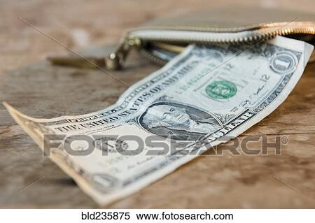 Stock Photography - Close up of dollar on wooden table near wallet. Fotosearch