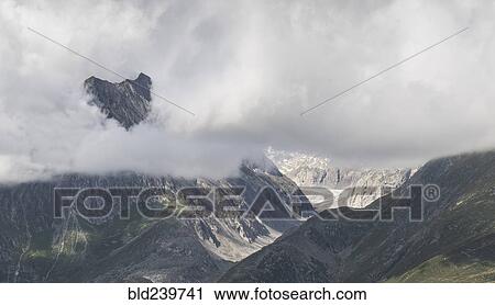 Stock Image - Clouds in remote mountain landscape. Fotosearch