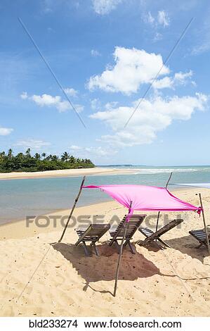 Picture - Clouds over ocean beach and deck chairs. Fotosearch