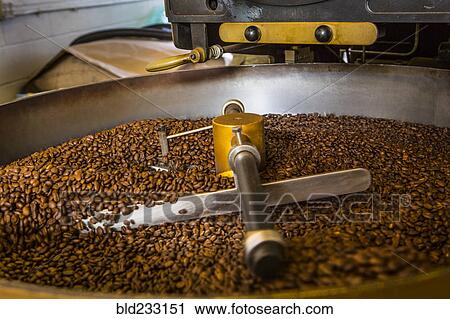 Stock Image - Coffee beans in roaster. Fotosearch