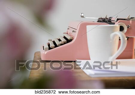 Coffee cup on pile of paper near pink typewriter View Large Photo Image Stock Image - Coffee cup on pile of paper near pink typewriter. Fotosearch