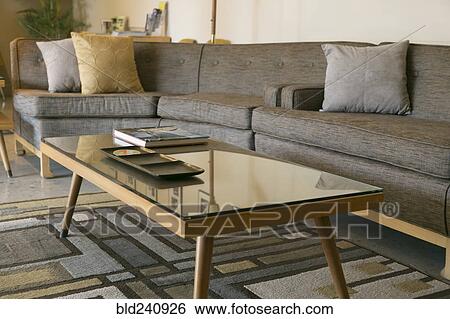 Stock Photograph - Coffee table with glass and sectional sofa. Fotosearch
