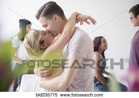 Stock Photography - Couple hugging and kissing at party. Fotosearch