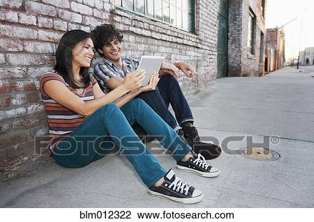 Couple sharing digital tablet outdoors View Large Photo Image Stock Image - Couple sharing digital tablet outdoors. Fotosearch