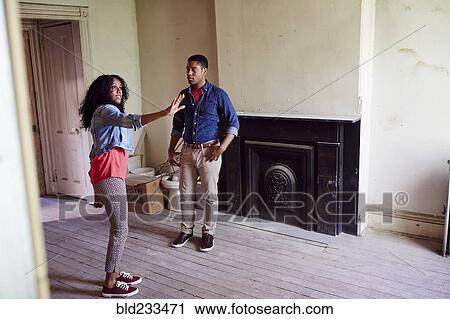 Stock Image - Couple talking in house under renovation. Fotosearch
