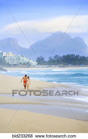 Couple walking on beach near waves View Large Photo Image Stock Photo - Couple walking on beach near waves. Fotosearch